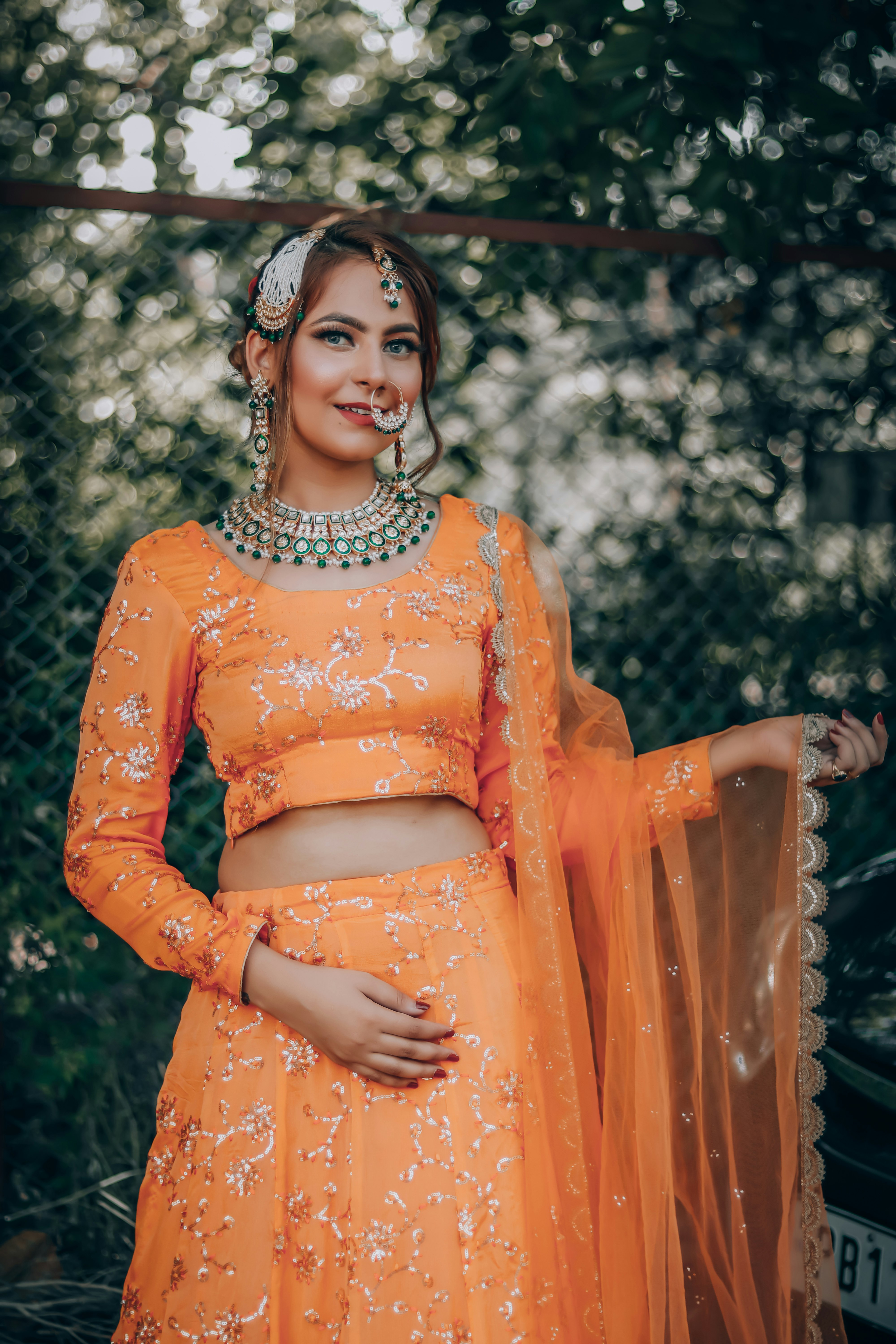 woman in orange long sleeve dress sitting on brown wooden armchair